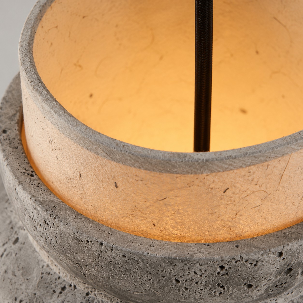 Close-up of glowing travertine stone shade rim and cord