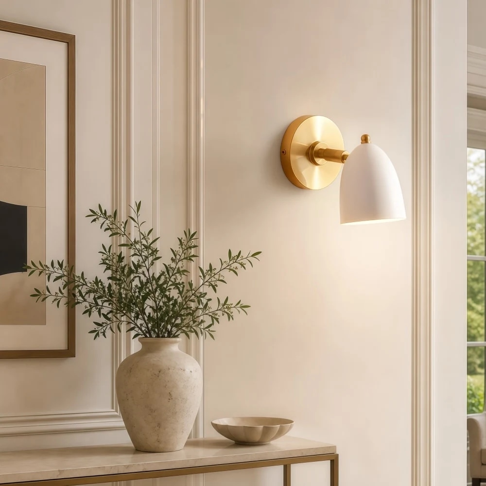 White and gold wall sconce installed beside artwork