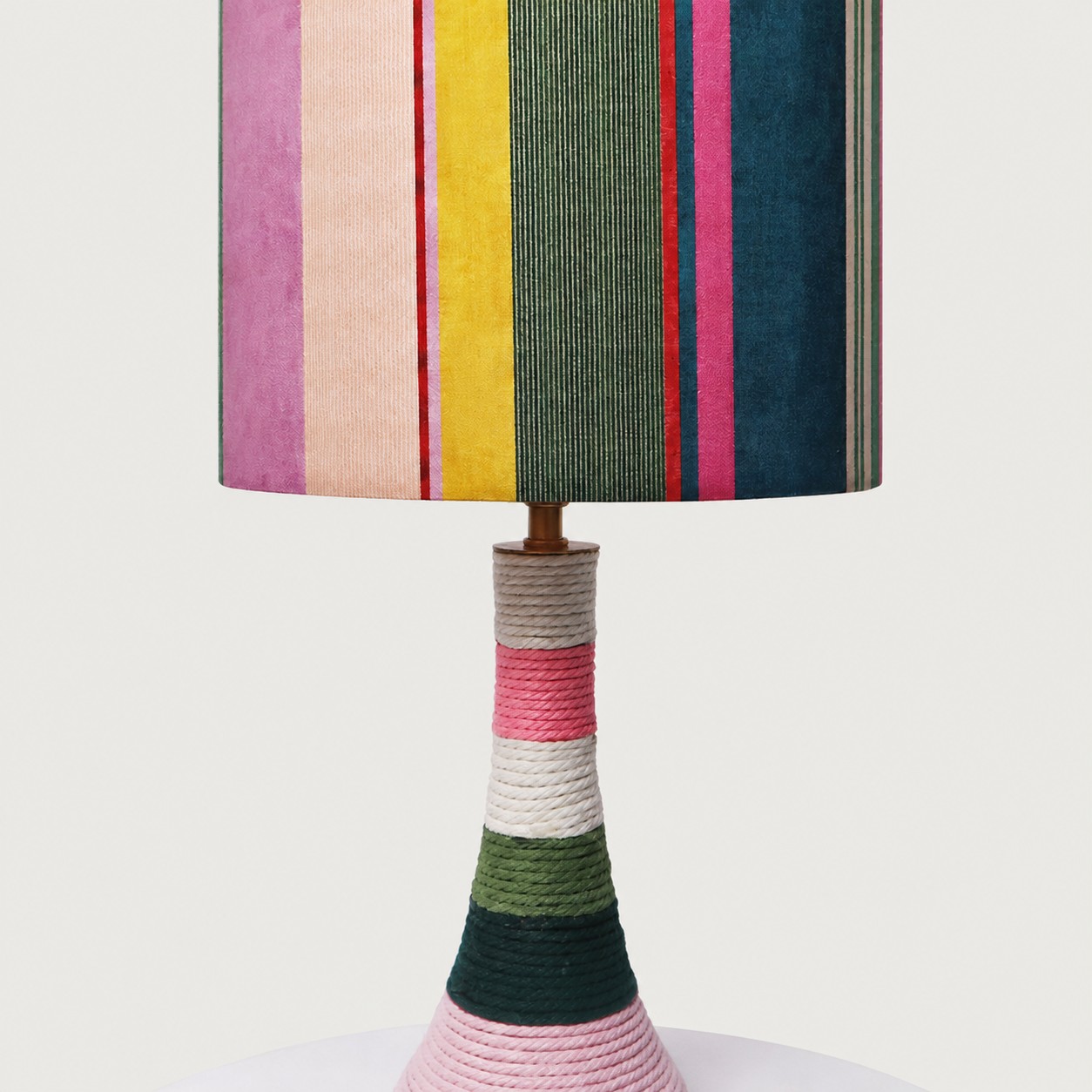 Close view of the colorful striped fabric shade and cotton-wrapped ceramic base