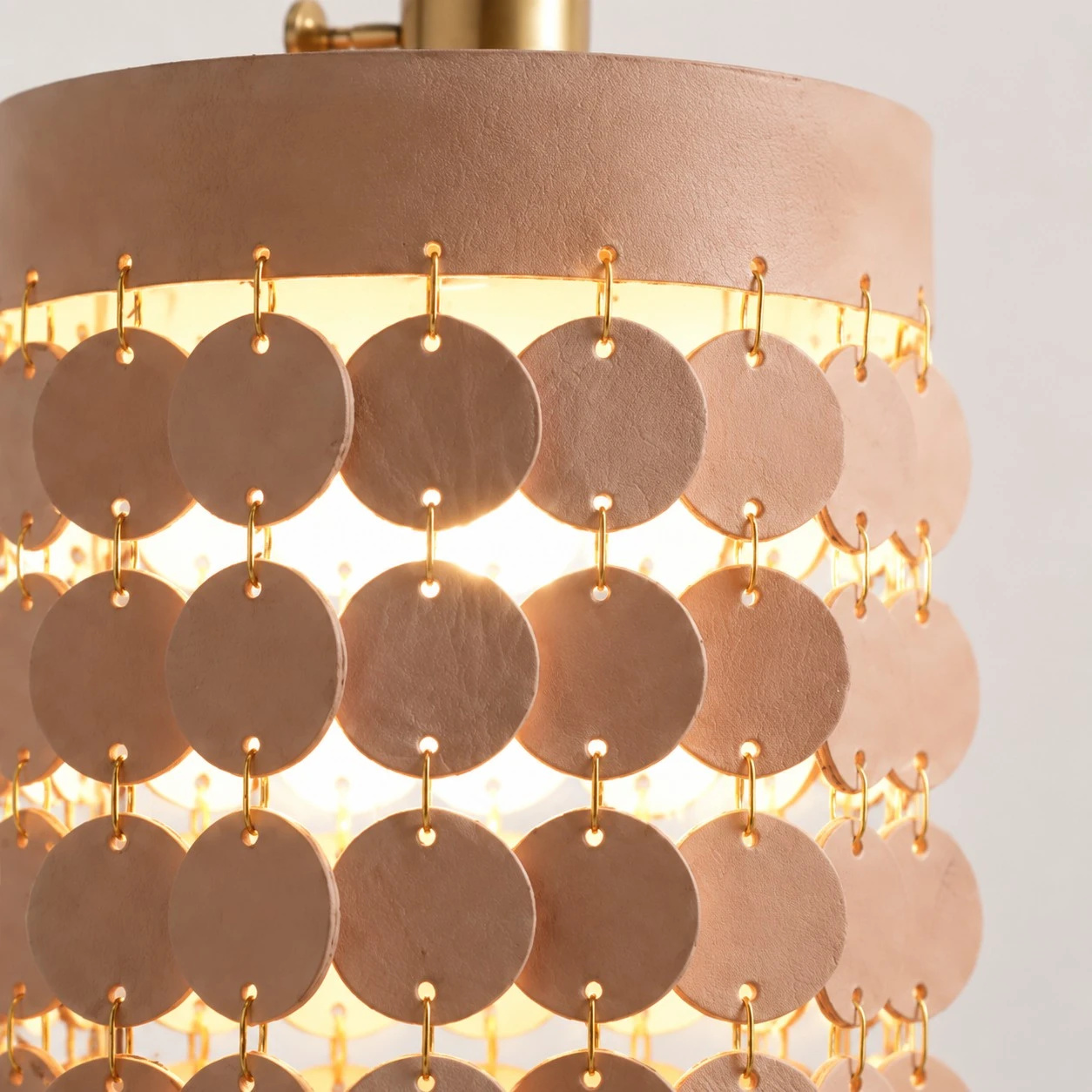 Layered leather discs joined with metal rings