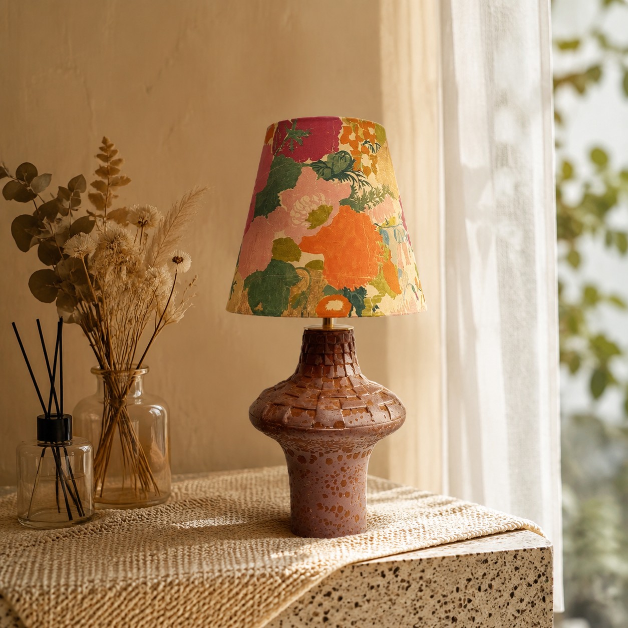 Orange floral ceramic table lamp on a textured console table